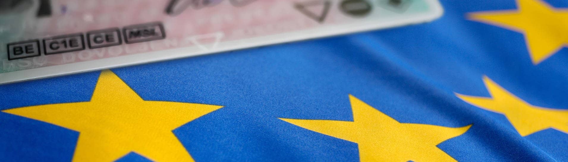 Ein Führerschein liegt auf einer Europaflagge.