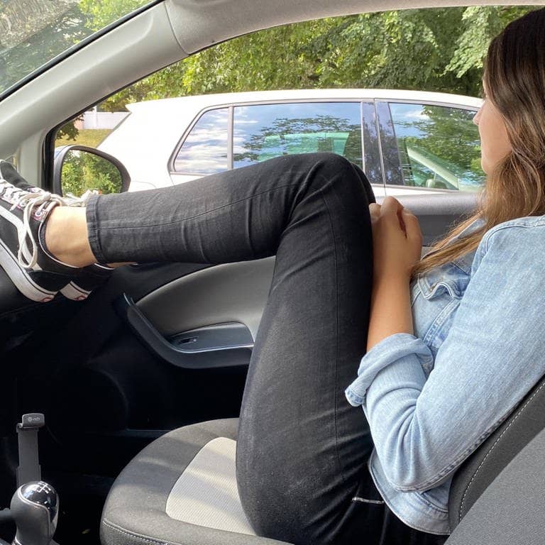 Frau in unsicherer Sitzposition im Auto