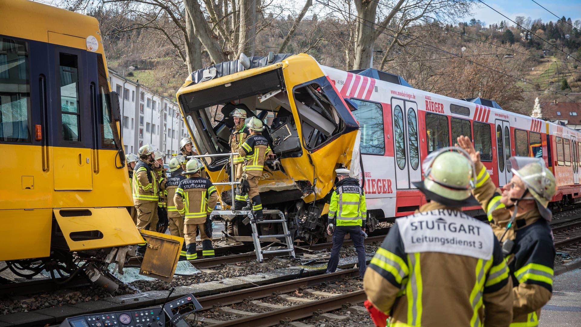 Einsatzkräfte der Feuerwehr arbeiten nach einem Unfall an zwei zerstörten Stadtbahnen in Stuttgart-Wangen.