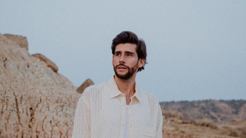 Alvaro Soler stehend in felsiger Landschaft