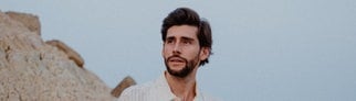 Alvaro Soler stehend in felsiger Landschaft