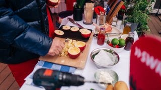 Zwischengang: Gegrillter gefüllter Apfel mit Reis auf einer grünen Salsa mit Rucola und Tomatenwürfel