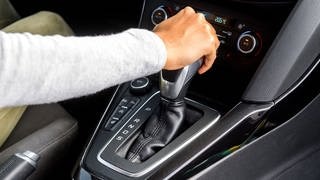 Arm, der die Gangschaltung im Auto festhält