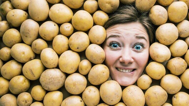 Gesicht einer Frau in einer Fläche aus Kartoffeln (Foto: Adobe Stock, karepa)