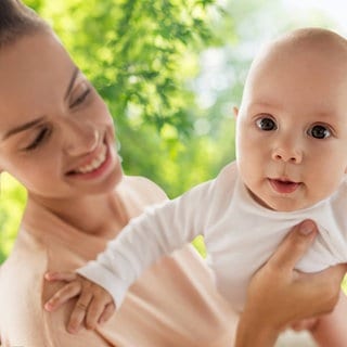 Mutter hält ihr Baby in die Kamera