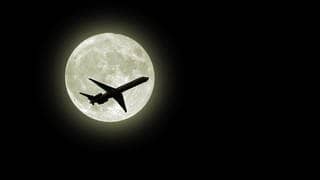 Flugzeug fliegt vor dem Mond
