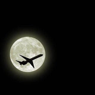 Flugzeug fliegt vor dem Mond