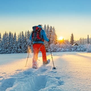 Schneeschuhwanderer läuft der Sonne entegegen