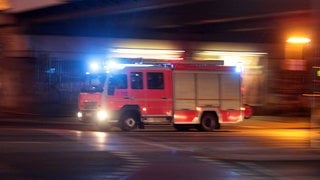 Spektakuläre Rettung durch Nachbarn in Bonn. Symbolbild: Ein Feuerwehrauto in voller Fahrt.