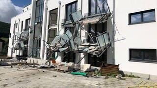 An einem Neubauhaus in Blumberg hängen zerstörte Balkone und andere Verkleidungen an der Fassade herunter.