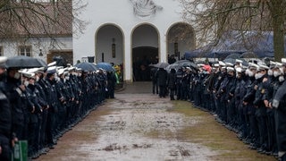 Polizisten und Polizistinnen stehen an der Kirche Spalier beim Gedenkgottesdienst für eine getötete Polizistin. Nach der Bestattung eines ermordeten Polizisten wird nun auch seine getötete Kollegin beigesetzt. Der 29 Jahre alte Polizeikommissar und die 24 Jahre alte Polizeianwärterin waren am 31. Januar während einer Fahrzeugkontrolle bei Kusel erschossen.