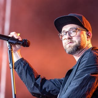 Sänger Mark Forster steht mit einem Mikofon in der Hand bei einem Konzert innerhalb seiner „Open Air Tour 2022“ auf der Bühne im Spreeauenpark.