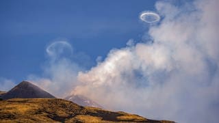 Der Vulkan Ätna in Sizilien spuckt Ringe aus Rauch in den Himmel.