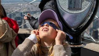 New York: Ein Kind verfolgt gespannt die Sonnenfinsternis.