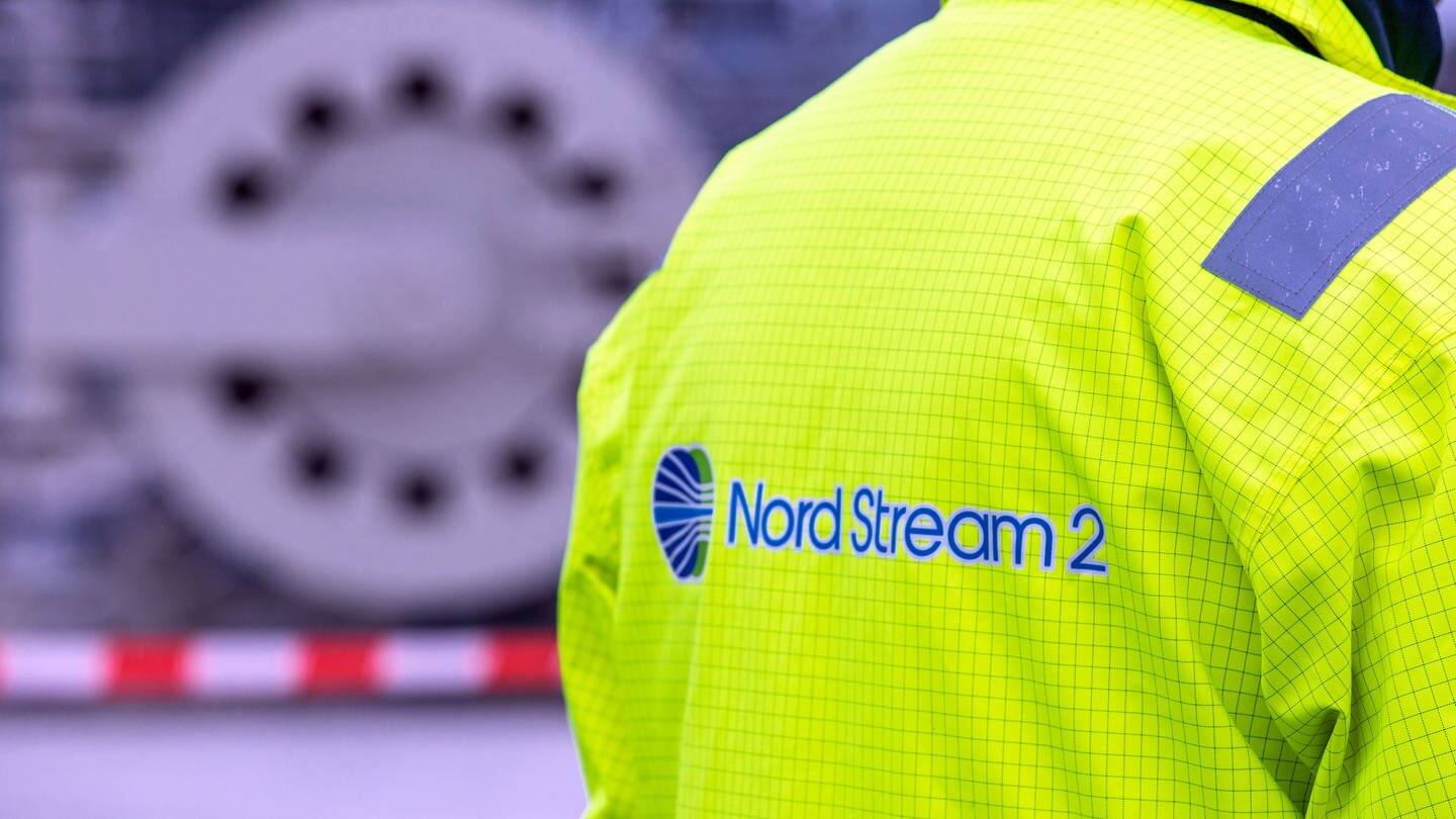 Ein Mitarbeiter mit einer Sicherheitsjacke von Nord Stream 2 steht vor der Molchstation in der Gasanlandestation von Nord Stream 2.