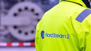 Ein Mitarbeiter mit einer Sicherheitsjacke von Nord Stream 2 steht vor der Molchstation in der Gasanlandestation von Nord Stream 2. 