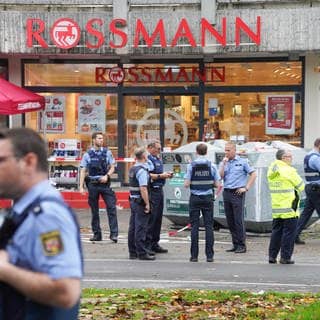 Polizisten und Rettungskräfte stehen an einem der Tatorte in Ludwigshafen-Oggersheim.