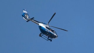 Ein Polizeihubschrauber fliegt über einem Tatort