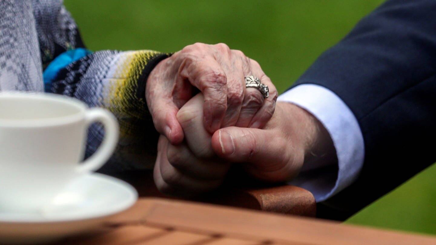 Eine Hand hält die Hand einer älteren Person fest