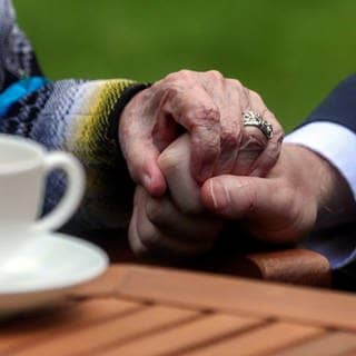 Eine Hand hält die Hand einer älteren Person fest