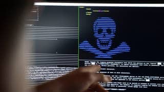 Auf einem PC-Monitor ist ein blauer Totenkopf aus Buchstaben vor schwarzem Grund wie bei einer Cyberattacke