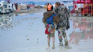 Ein verkleidetes Pärchen läuft durch das Wasser beim Burning Man