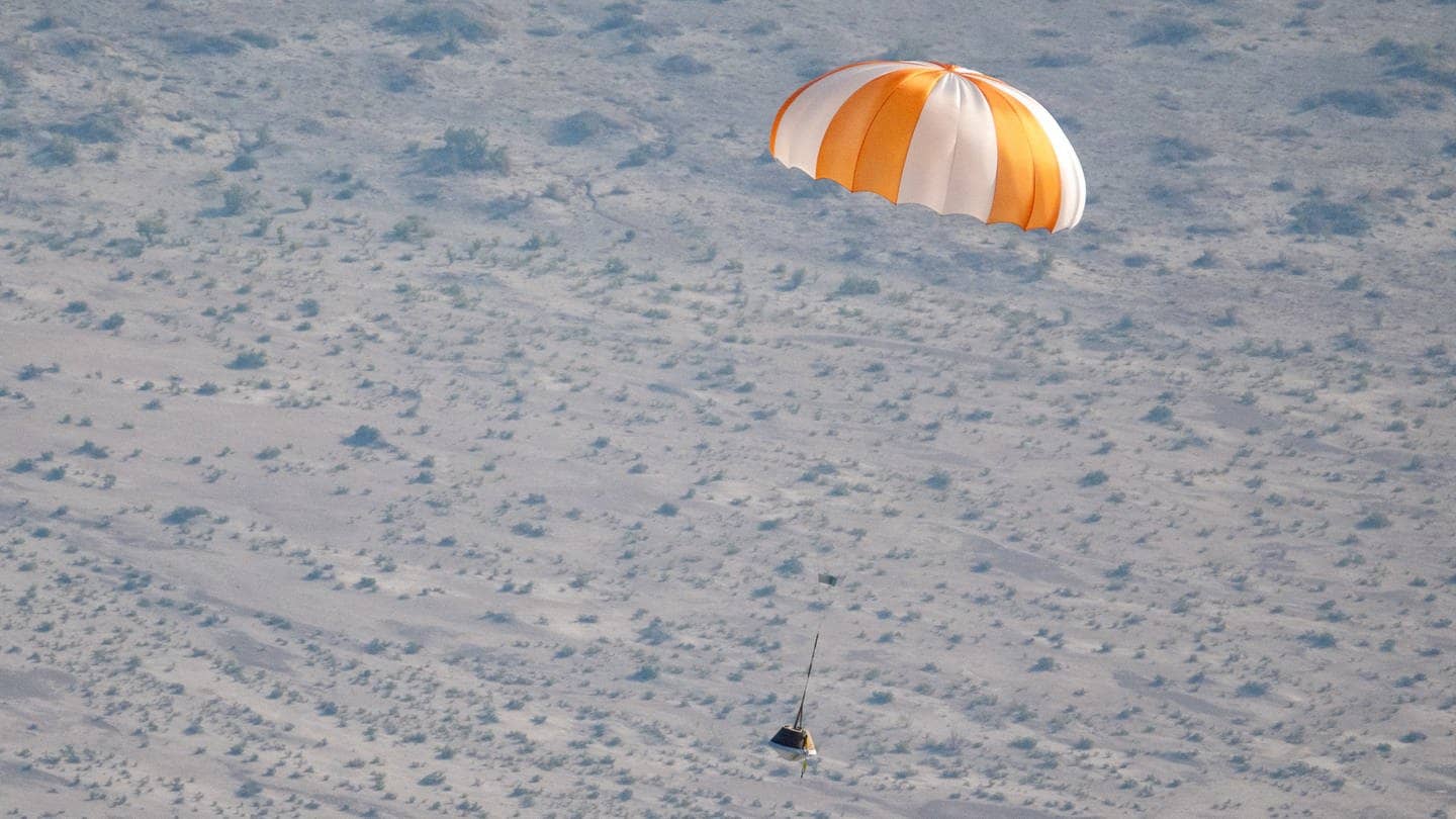 Ein Modell der Probenkapsel gleitet bei einem Test an einem Fallschirm über der Wüste in Utah auf einem Übungsgelände des US-Militärs zu Boden.