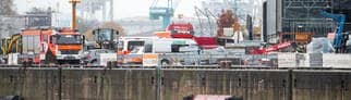 Einsatzfahrzeuge von Feuerwehr und Polizei stehen in der Hafencity auf einer Baustelle.