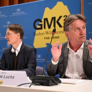 Manfred Lucha (Bündnis 90Grüne, r), Gesundheitsminister aus Baden-Württemberg, spricht bei der Pressekonferenz zum Abschluss der Gesundheitsminister-Konferenz, während Bundesgesundheitsminister Karl Lauterbach (SPD,l) daneben sitzt.