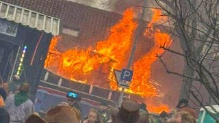 Ein Faschingswagen steht brennend auf einer Straße. Bei einem Faschingsumzug im baden-württembergischen Kehl ist am Sonntag ein Faschingswagen in Brand geraten.