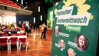 Ein Plakat mit der Aufschrift "Politischer Aschermittwoch" hängt beim politischen Aschermittwoch der baden-württembergischen Grünen in der Stadthalle in Biberach.