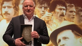 Andreas Brehme, ehemaliger deutscher Fußballspieler, hält seine Trophäe auf der Bühne bei der Gala  zur Einweihung der Hall of Fame des deutschen Fußballs im Deutschen Fußballmuseum. 