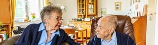 Ursula und Gottfried Schmelzer sitzen in ihrem Wohnzimmer zusammen. Die beiden sind seit 80 Jahren verheiratet.