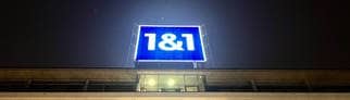 Das leuchtende Logo von 1&1 ist auf dem Dach der Firmenzentrale in Montabaur bei Nacht zu sehen.