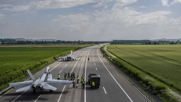 Zwei Kampfflugzeuge vom Typ FA-18 sind auf der Autobahn A1 gelandet und werden gewartet.