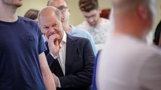 Bundeskanzler Olaf Scholz (SPD) steht wartend in einer Schlange in seinem Wahllokal, um seine Stimme für die Europawahl abzugeben.