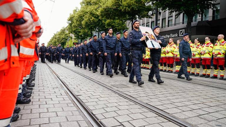 Polizisten gehen bei einem Trauermarsch für den bei einer Messerattacke tödlich verletzten Polizisten Rouven Laur durch die Innenstadt. Er starb nach der Attacke am 31. Mai. 