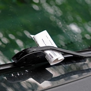 Strafzettel hängt unter dem Scheibenwischer eines Autos. Symbolbild für die Knöllchen, die in der Stadt Frankenthal gerade auftauchen.