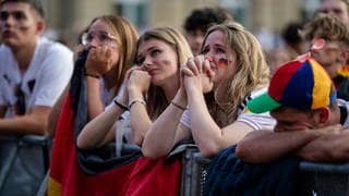 Traurige Fans im Stadion bei der EM 2024 nach dem Aus für Deutschland.