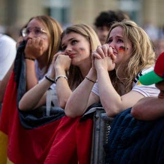 Traurige Fans im Stadion bei der EM 2024 nach dem Aus für Deutschland.