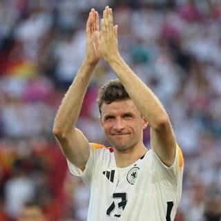 Fußballnationalspieler Thomas Müller klatscht über dem Kopf in die Hände