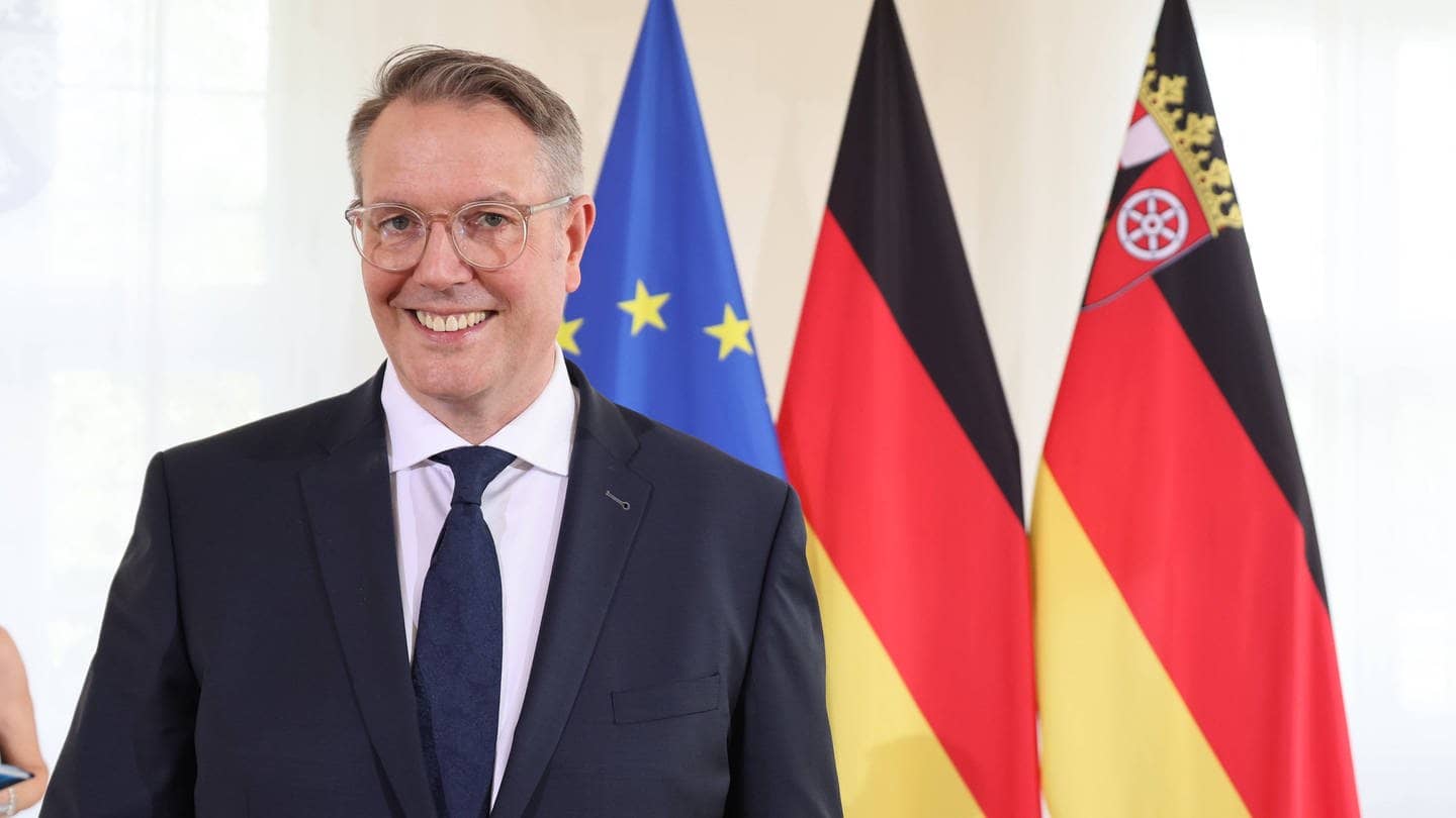 Der neue Ministerpräsident von Rheinland-Pfalz, Alexander Schweitzer (SPD), steht vor der EU-, der Deutschland- und der RLP-Flagge