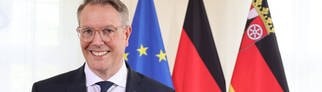 Der neue Ministerpräsident von Rheinland-Pfalz, Alexander Schweitzer (SPD), steht vor der EU-, der Deutschland- und der RLP-Flagge