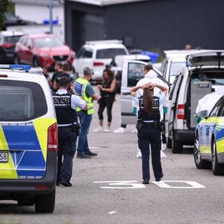 Polizisten stehen an einer Straße bei einem Einsatz in Albstadt-Lautlingen. Bei einem Großeinsatz in Albstadt auf der Schwäbischen Alb haben Polizisten drei Tote und zwei Verletzte gefunden.