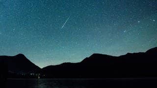 Eine Sternschnuppe leuchtet am 12.08.2018 am Himmel über dem Walchensee (Archiv).