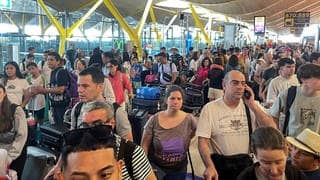Nach weltweiten Computerproblemen gestrandete Passagier stehen ratlos am Barajas-Flughafen in Madrid und telefonieren mit ihren Handys.