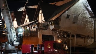 Ein Fahrzeug der Feuerwehr steht vor einem eingestürzten Hotel im Moselort Kröv im Landkreis Bernkastel-Wittlich (Rheinland-Pfalz)