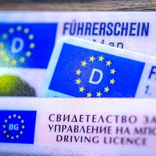 Ein bulgarischer und zwei deutsche Führerscheine liegen auf einem Tisch.