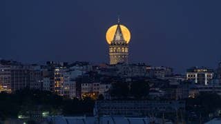 Wunderschön orangefarben leuchtet der Supermond über dem historischen Galata-Turm in Istanbul.