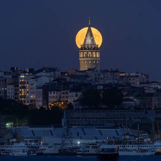 Wunderschön orangefarben leuchtet der Supermond über dem historischen Galata-Turm in Istanbul.